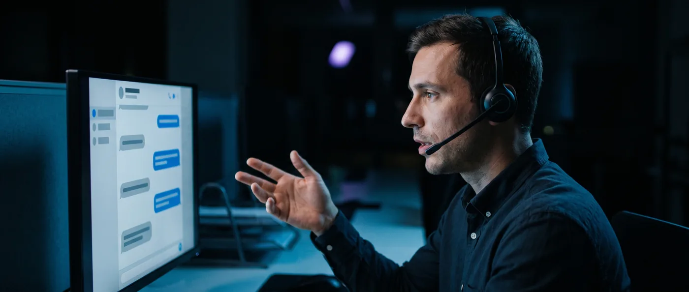 A professional on a headset call, working through a customer message thread on screen.